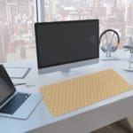 Infidu Light Beige Desk Pad with a small white dot pattern, creating a subtle and minimalist design for a clean desk setup. A computer and laptop are next to the desk pad