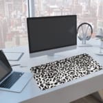 Infidu White Leopard Print Desk Pad features black spots on a white background, creating a classic and stylish leopard print design A computer and laptop are next to the desk pad
