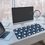 Infidu Dark Blue Desk Pad with white circles, light blue stripes, and snowflake pattern. A computer and laptop are next to the desk pad