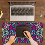 Infidu Colorful Mandala Design Desk Pad with intricate blue, pink, and purple patterns on a light background. A writing pad on top of the desk pad