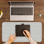 Infidu Light Gray Desk Mat with a subtle color effect, featuring a soft, monochromatic gray background with no prominent patterns. A writing pad on top of the desk pad