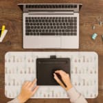 Infidu Chess Piece Design Desk Mat featuring chess pieces in soft pastel colors with a light background. A writing pad on top of the desk pad