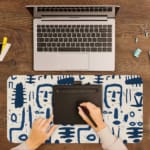 Blue tribal symbols desk pad with abstract patterns on a dim white background. A writing pad on top of the desk pad