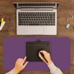 Desk pad with a purple textured background and black diamond design. A writing pad on top of the desk pad