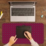 Pink desk pad with a pattern of small dots. A writing pad on top of the desk pad