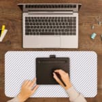 Desk pad with a white background and light gray diagonal stripes. A writing pad on top of the desk pad