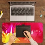 Desk pad with a vibrant pink and yellow abstract design. A writing pad on top of the desk pad