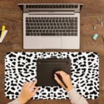 Infidu Black Leopard Print Desk Pad features a bold black leopard print pattern on a white background, offering a modern and stylish look. A writing pad on top of the desk pad
