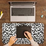 Infidu White Leopard Print Desk Pad features black spots on a white background, creating a classic and stylish leopard print design A writing pad on top of the desk pad