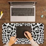 Infidu White Desk Pad with black leopard print spots on a white background, featuring a bold and untamed animal print design. A writing pad on top of the desk pad