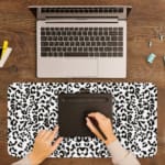 Infidu White Leopard Print Desk Pad features black spots on a white background, creating a classic and stylish leopard print design. A writing pad on top of the desk pad
