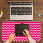 Infidu Vibrant Pink and White Striped Desk Mat with dynamic alternating pink and white stripes. A writing pad on top of the desk pad
