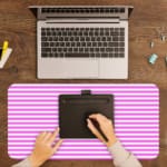 Pink and white striped desk pad with horizontal lines on a white background. A writing pad on top of the desk pad