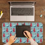 Infidu desk pad with red Christmas trees and blue teacups on a light blue background, creating a festive and cheerful design. A writing pad on top of the desk pad