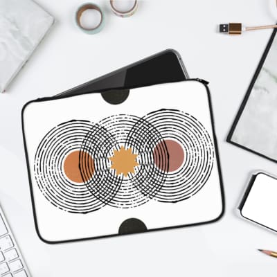 Laptop sleeve featuring a minimalist design with black, orange, and brown concentric circles on a white background, with durable fabric and zip. laptop sleeve kept on a plain white background