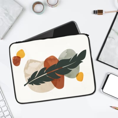 Elegant feather motif abstract design in muted tones on a fabric laptop sleeve. laptop sleeve kept on a plain white background