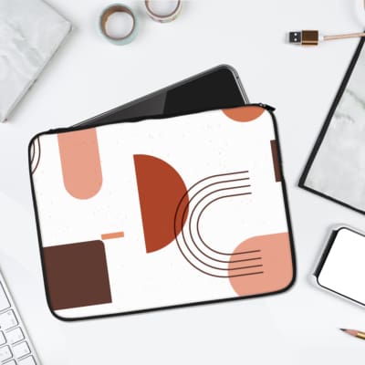 Infidu Modern Abstract Geometric Shapes Laptop Sleeve featuring vibrant arcs, rectangles, and circles in red, pink, and maroon on a white background. laptop sleeve kept on a plain white background