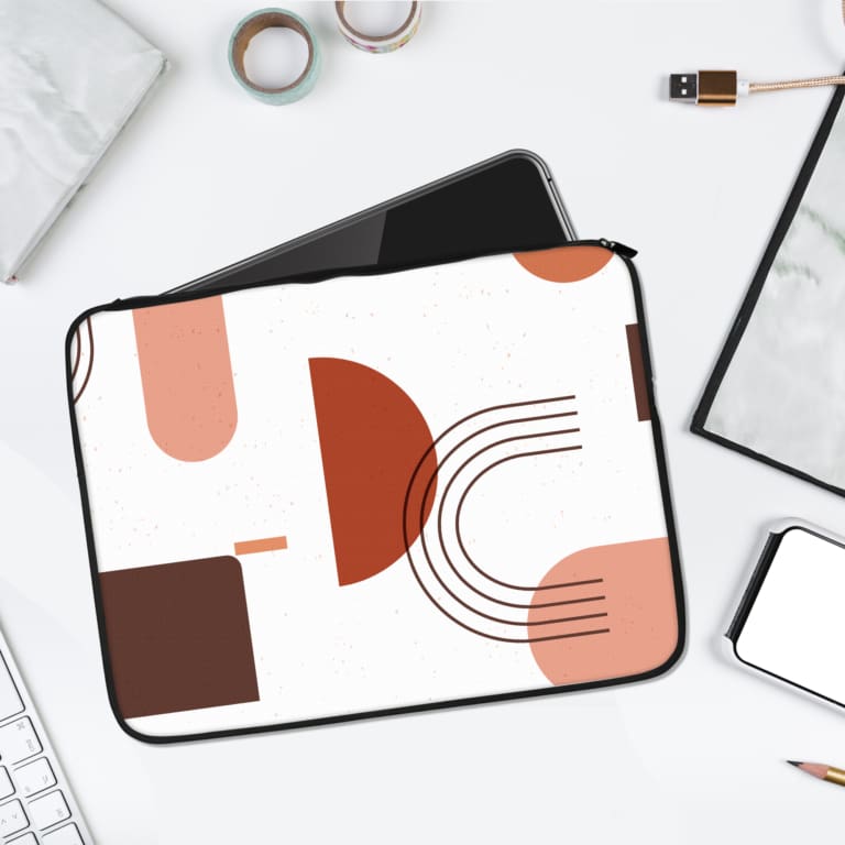 Infidu Modern Abstract Geometric Shapes Laptop Sleeve featuring vibrant arcs, rectangles, and circles in red, pink, and maroon on a white background. laptop sleeve kept on a plain white background