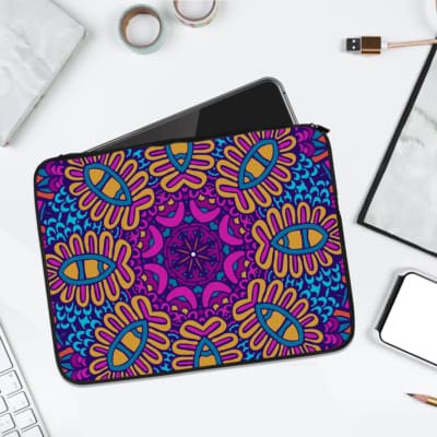 Vibrant purple laptop sleeve with yellow, blue, and orange mandala-style geometric patterns and secure zip closure. laptop sleeve kept on a plain white background