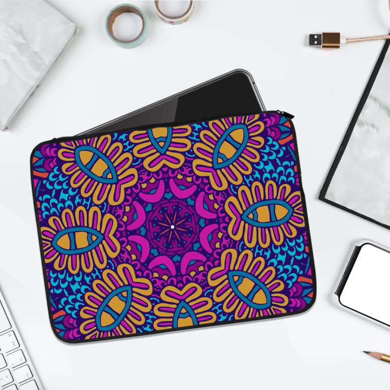 Vibrant purple laptop sleeve with yellow, blue, and orange mandala-style geometric patterns and secure zip closure. laptop sleeve kept on a plain white background