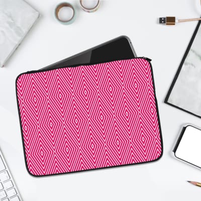 Pink laptop sleeve with bold white diamond geometric pattern, stylish and modern design. laptop sleeve kept on a plain white background