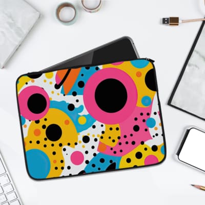 Playful and colorful laptop sleeve featuring a white background with large pink, yellow, turquoise circles and smaller colorful dots. laptop sleeve kept on a plain white background