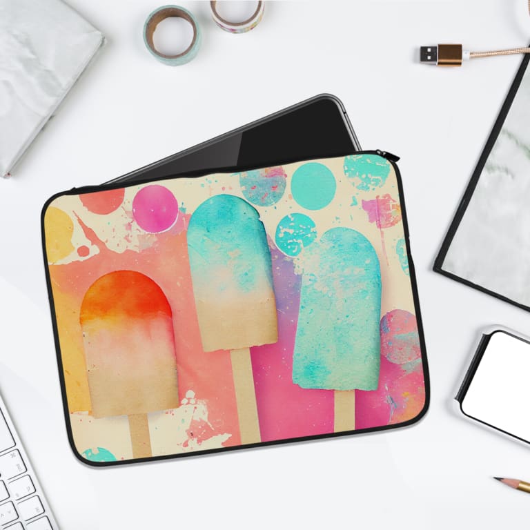 Laptop sleeve with pastel-colored ice cream pops design in pink, blue, and orange, featuring a durable fabric with zip closure. laptop sleeve kept on a plain white background