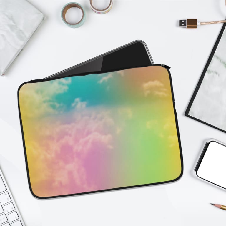 Dreamy cloudy rainbow sky laptop sleeve with colorful shades of blue, yellow, pink, and green on a durable fabric sleeve. laptop sleeve kept on a plain white background