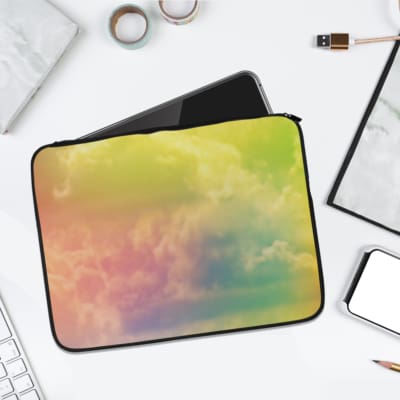 Gradient cloudy sky pastel laptop sleeve with yellow, orange, pink, and green hues, featuring a secure zip closure for stylish protection. laptop sleeve kept on a plain white background