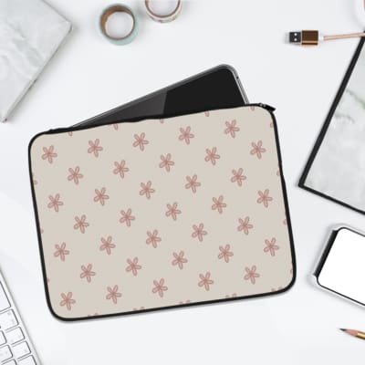 Beige laptop sleeve with subtle floral design, featuring small, evenly spaced floral patterns in neutral tones. laptop sleeve kept on a plain white background