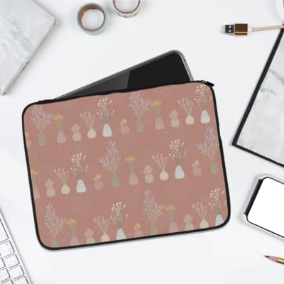 Pastel floral design laptop sleeve with vases in soft shades of pink, yellow, white, and beige. laptop sleeve kept on a plain white background