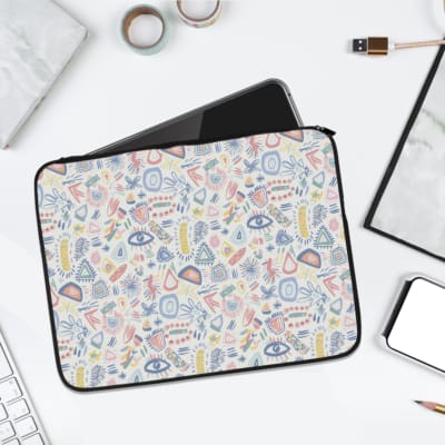 Whimsical pastel icon design laptop sleeve with small icons like eyes and leaves in pastel shades on a light-colored background. laptop sleeve kept on a plain white background