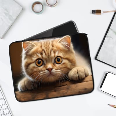 Laptop sleeve featuring a light brown tabby cat with curious eyes, made from durable fabric and a secure zip closure for laptop protection. laptop sleeve kept on a plain white background