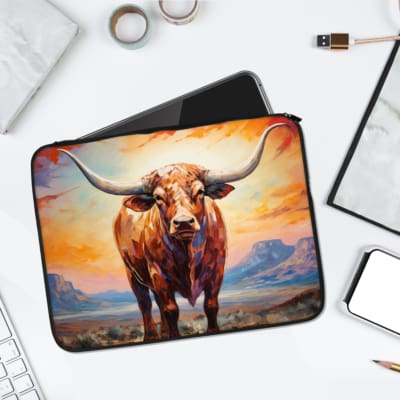 A vibrant laptop sleeve with a realistic bull painting, set against a scenic field with an orange and blue sky, featuring a secure zip closure. laptop sleeve kept on a plain white background