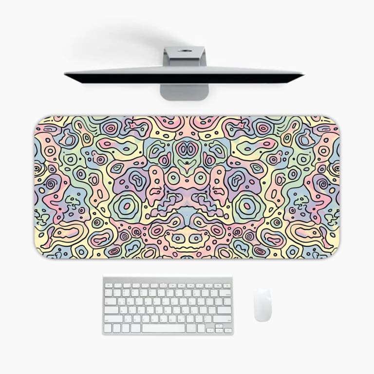 Infidu Abstract Desk Pad featuring swirling pastel patterns in pink, blue, and purple on a light off-white background. A desk pad under the computer
