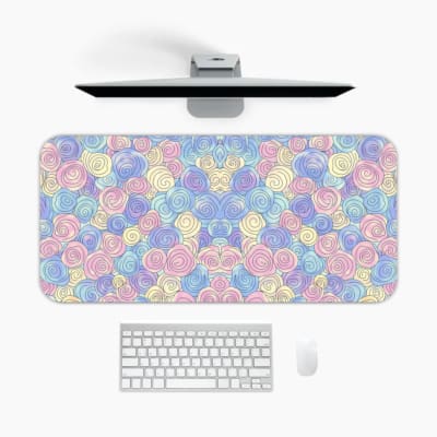 Infidu desk pad featuring colorful pastel abstract design with pink, blue, and purple patterns against a light blue background. A desk pad under the computer