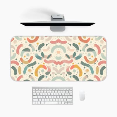 Infidu desk pad with a modern abstract pattern in muted colors on a light background, featuring curved shapes and lines. A desk pad under the computer