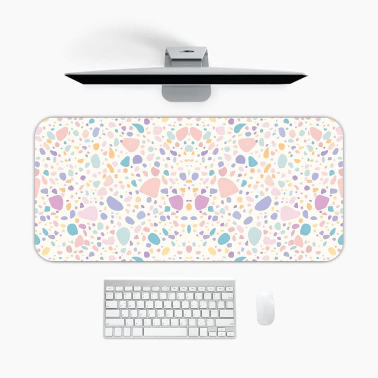 Infidu desk pad with terrazzo-style pattern in pastel colors on a light background, featuring small scattered shapes for a subtle modern look. A desk pad under the computer