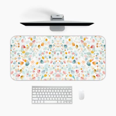 Infidu Pastel Desk Pad with light background and soft abstract shapes in pastel colors like pink, blue, yellow, and green. A desk pad under the computer