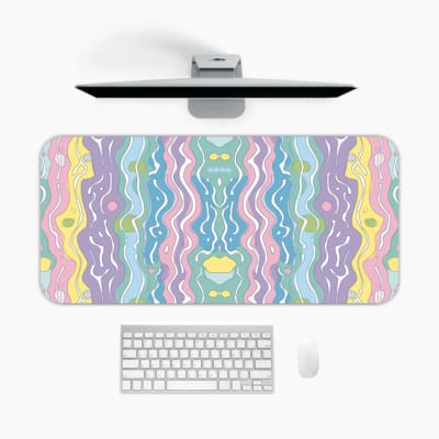 Infidu Wavy Desk Pad featuring a calm pastel ripple design in light blue, purple, pink, yellow, and green colors on a blended background. A desk pad under the computer