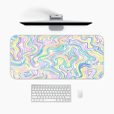 Infidu Wavy Desk Pad showcases colorful abstract lines in shades of yellow, green, blue, purple, and pink on a light background. A desk pad under the computer