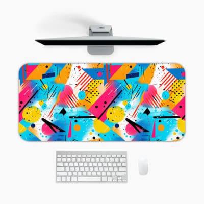 Colorful desk pad with geometric shapes in pink, yellow, blue, and teal against a light background, retro abstract design. A desk pad under the computer