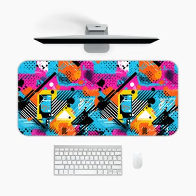 Infidu Vibrant Desk Pad featuring a bold abstract geometric design with bright colors including blue, pink, orange, and yellow. A desk pad under the computer