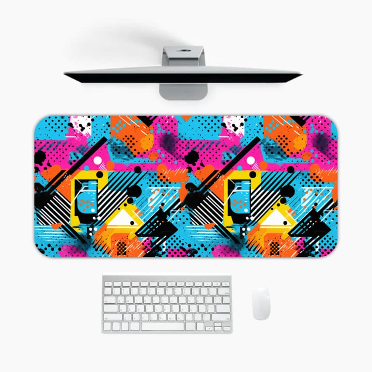 Infidu Vibrant Desk Pad featuring a bold abstract geometric design with bright colors including blue, pink, orange, and yellow. A desk pad under the computer