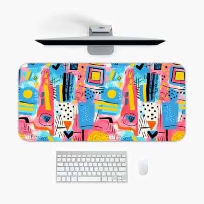 Infidu Pastel Geometric Desk Pad with colorful abstract shapes in pastel shades on a light background with blue, pink, yellow, and green tones. A desk pad under the computer