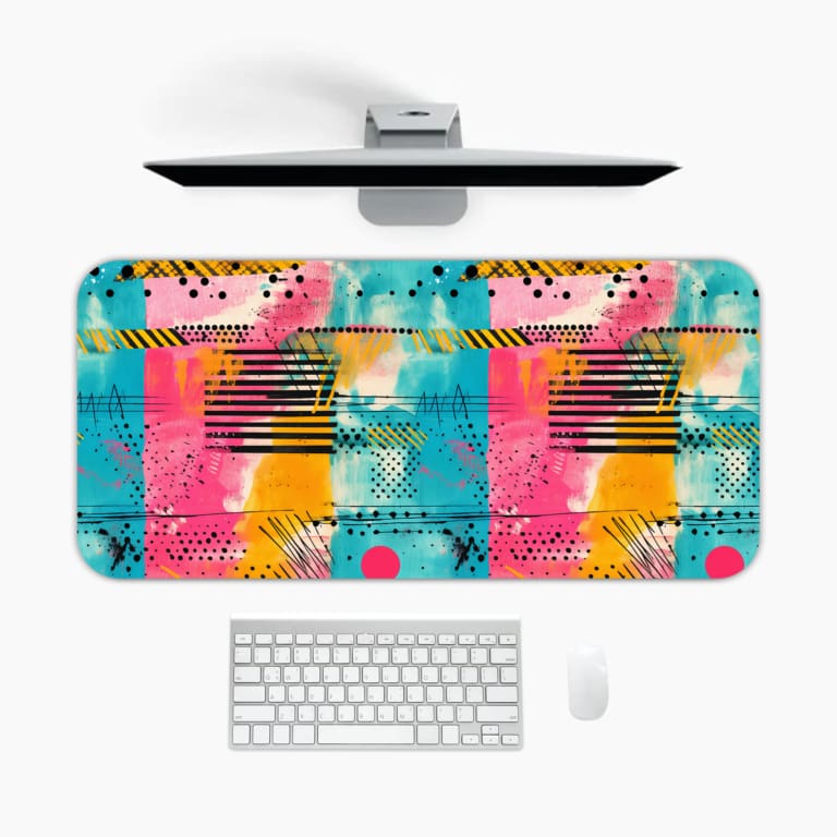 Infidu desk pad with vibrant abstract pattern featuring shades of blue, pink, orange, and yellow with black lines and dots. A desk pad under the computer
