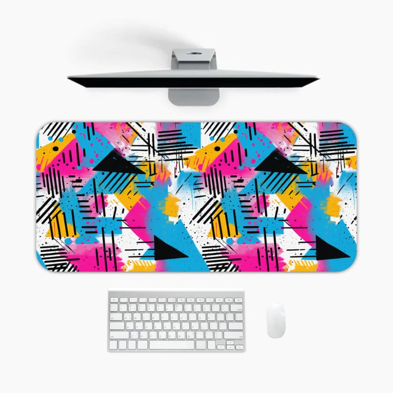 Infidu Colorful Desk Pad featuring an abstract geometric design with bright shapes in pink, blue, yellow, and black on a modern background. A desk pad under the computer