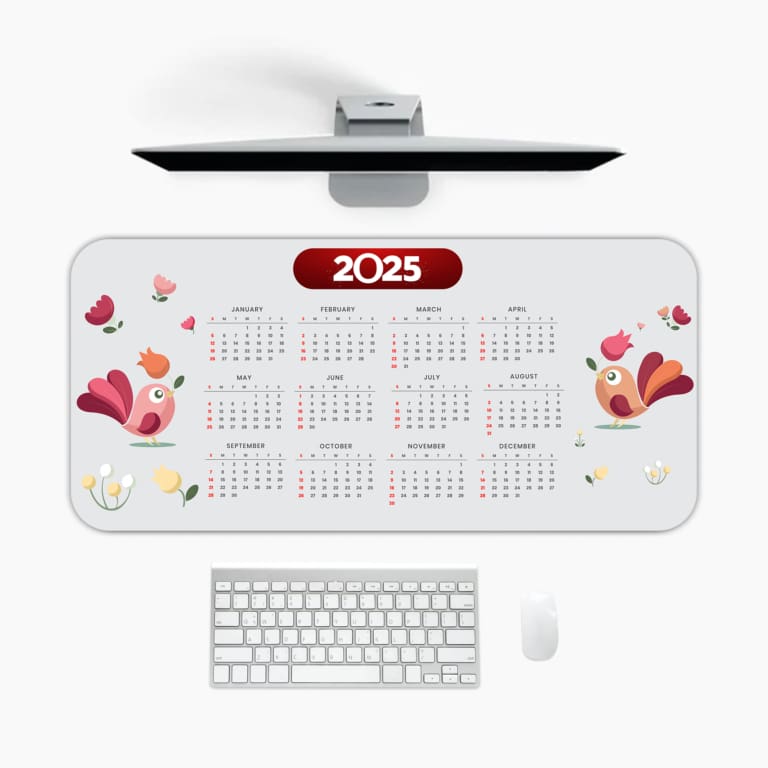 Infidu 2025 Desk Mat with white background, pink floral accents, and 2025 on a red oval label A desk pad under the computer