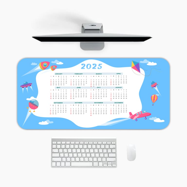 2025 desk pad with a bright blue sky background, white clouds, and playful elements like kites, balloons, and airplanes A desk pad under the computer
