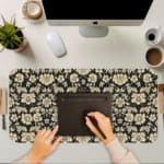 Infidu Floral Desk Pad featuring intricate white flowers on a black background, showcasing a stylish and elegant design. A writing pad on top of the desk pad